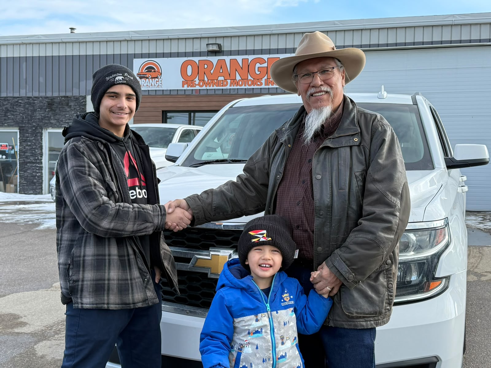 Happy Orange Auto customer with their vehicle