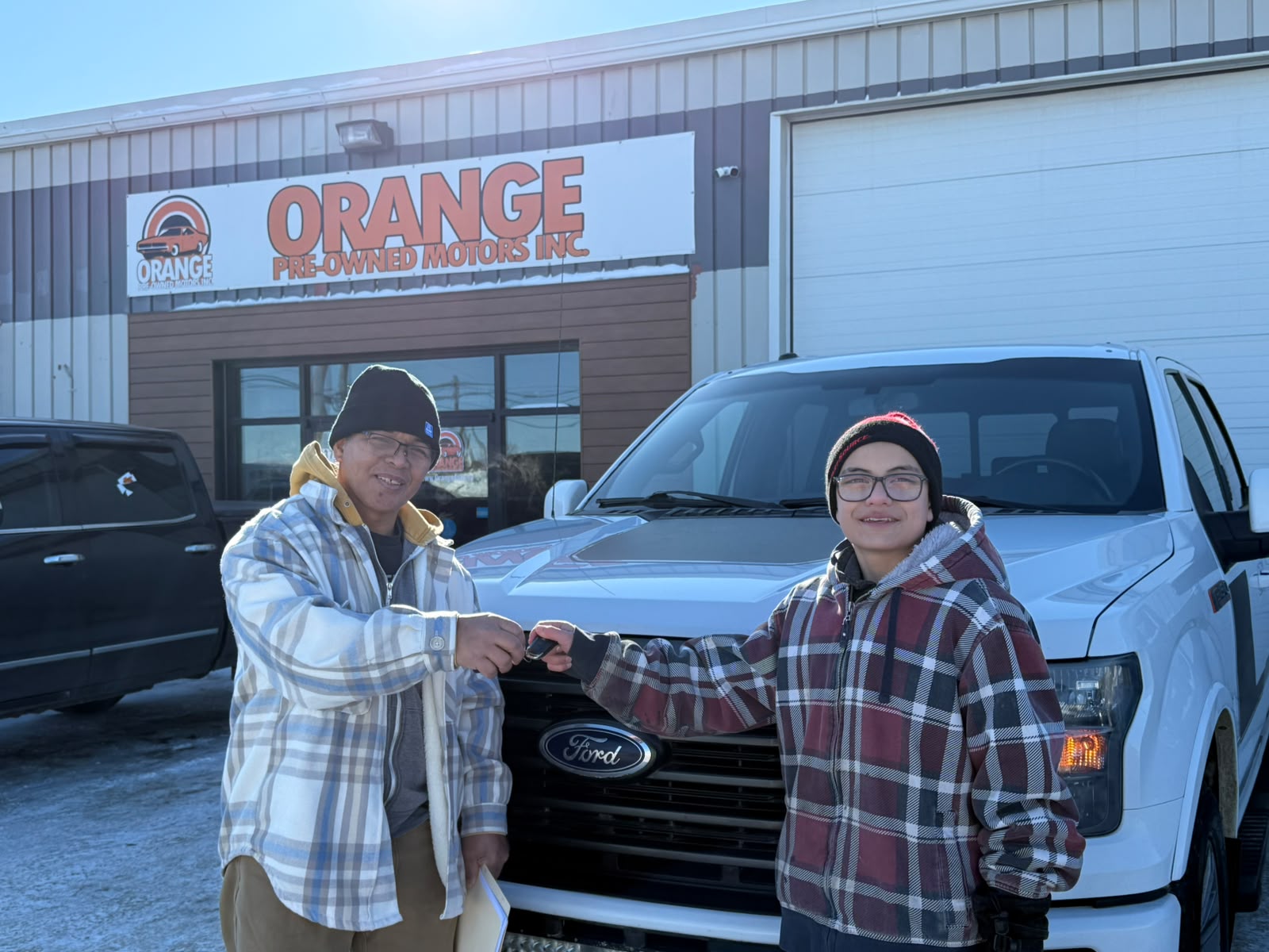 Happy Orange Auto customer with their vehicle