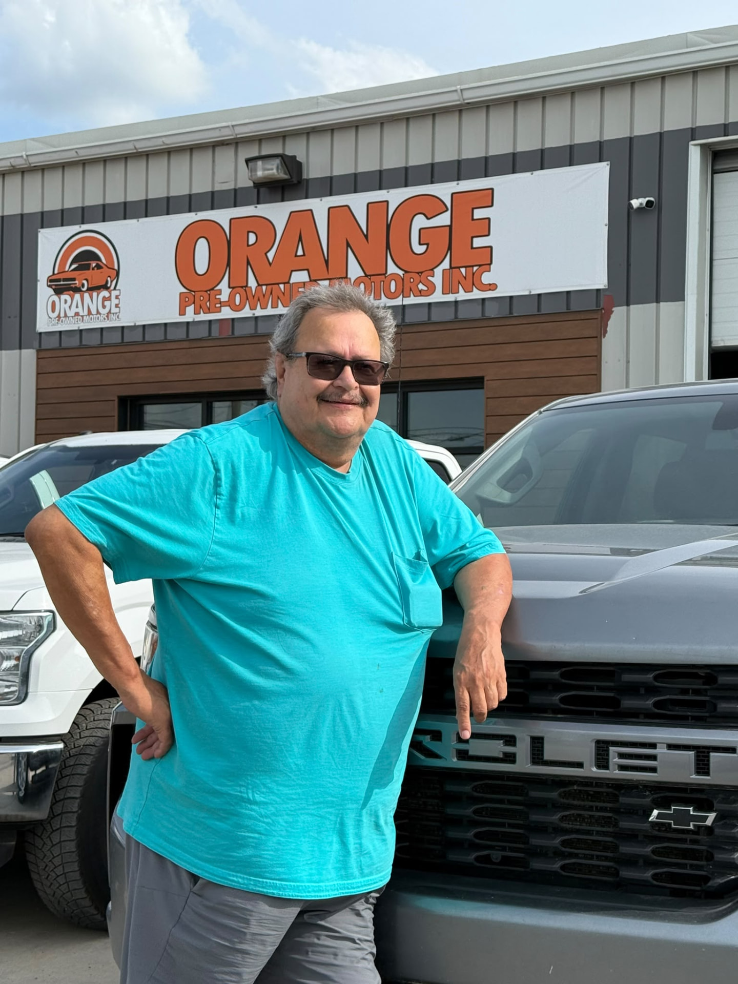 Happy Orange Auto customer with their vehicle
