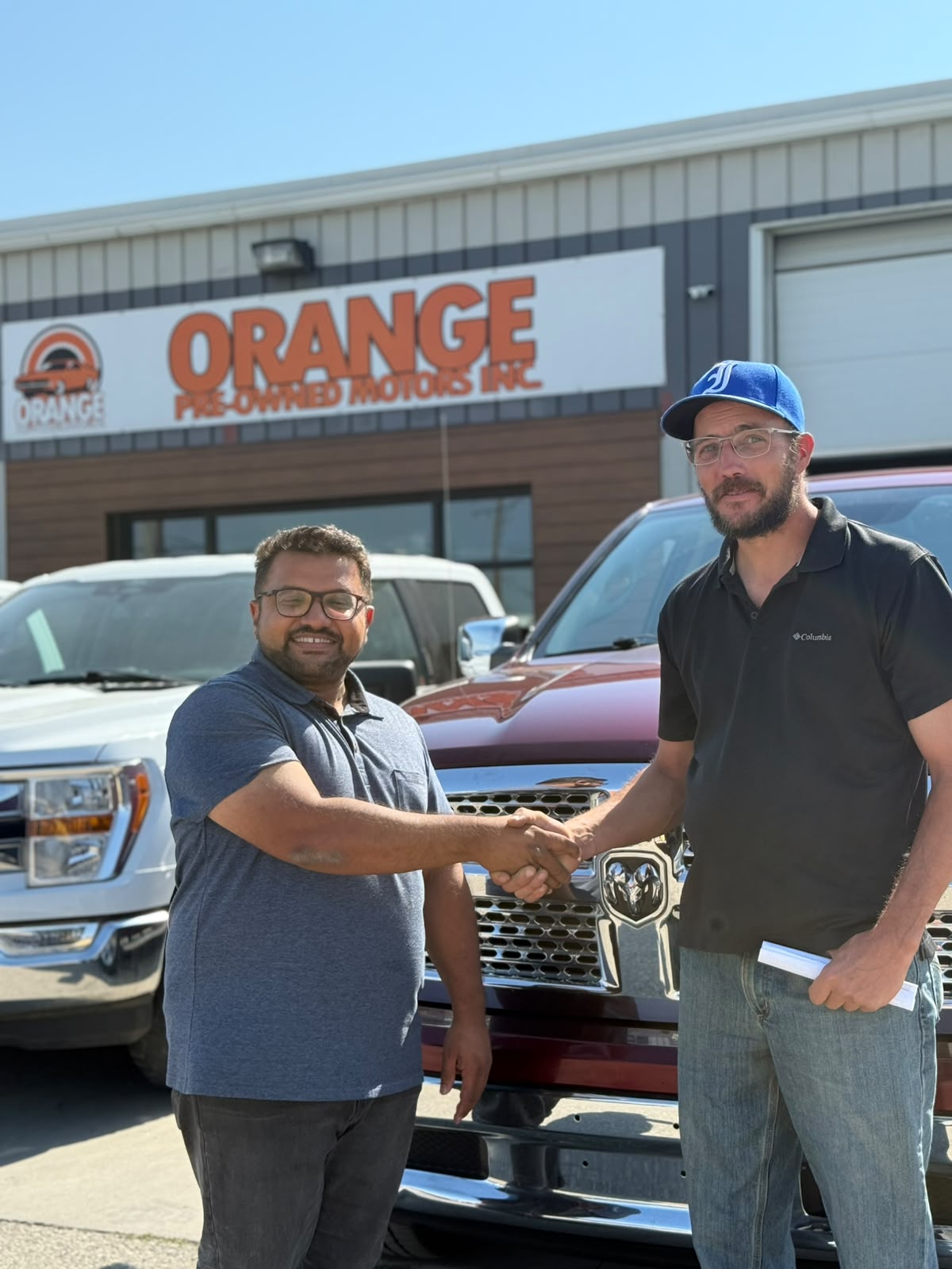 Happy Orange Auto customer with their vehicle