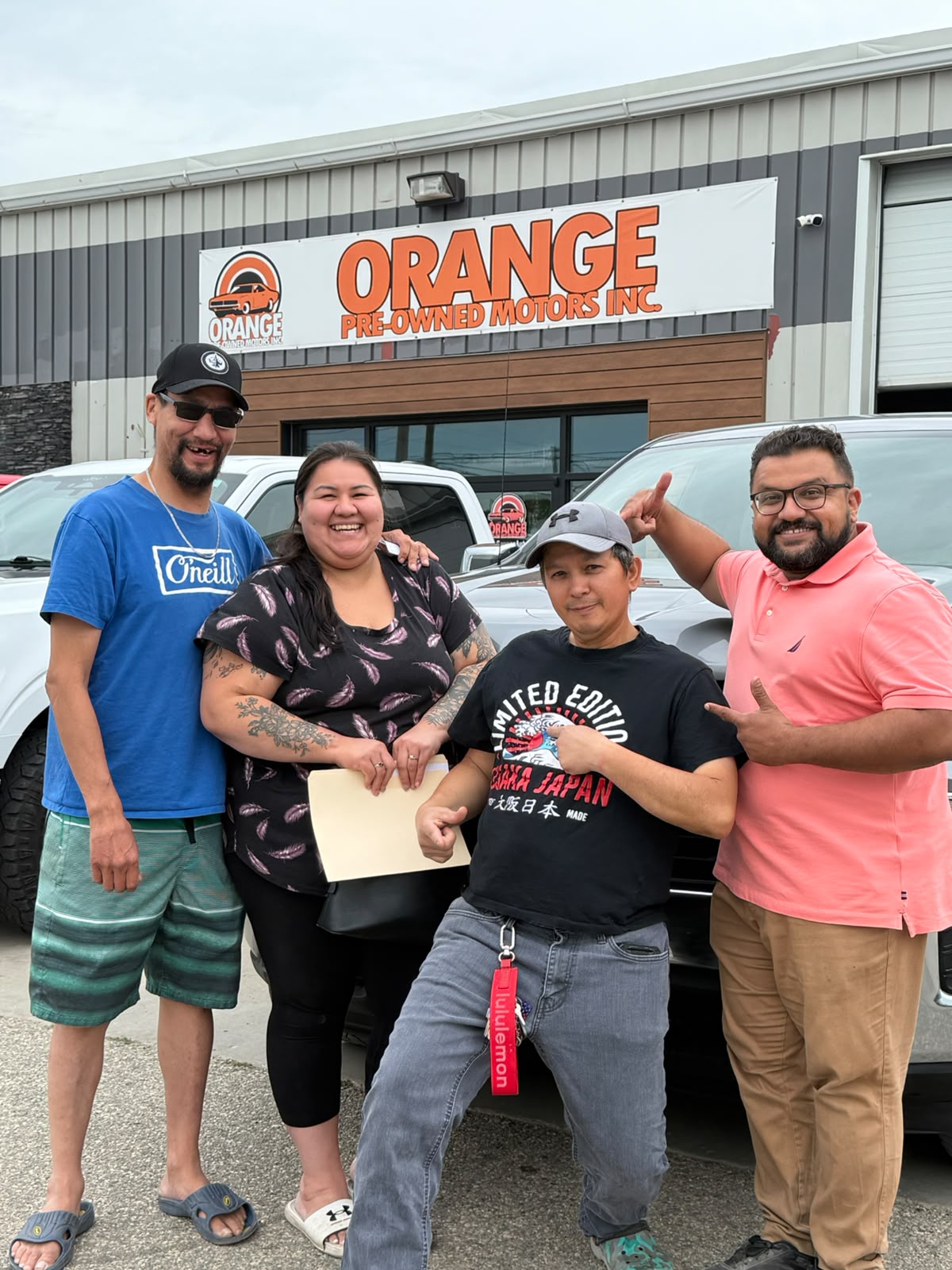 Happy Orange Auto customer with their vehicle