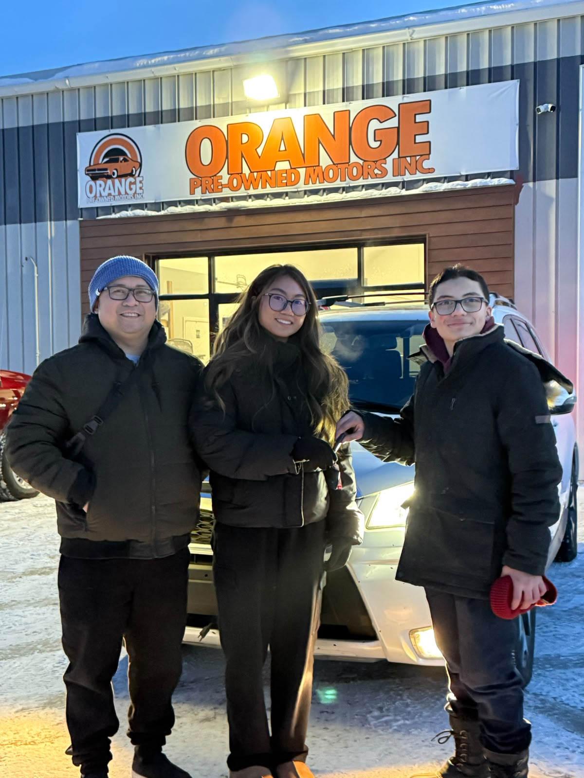 Happy Orange Auto customer with their vehicle