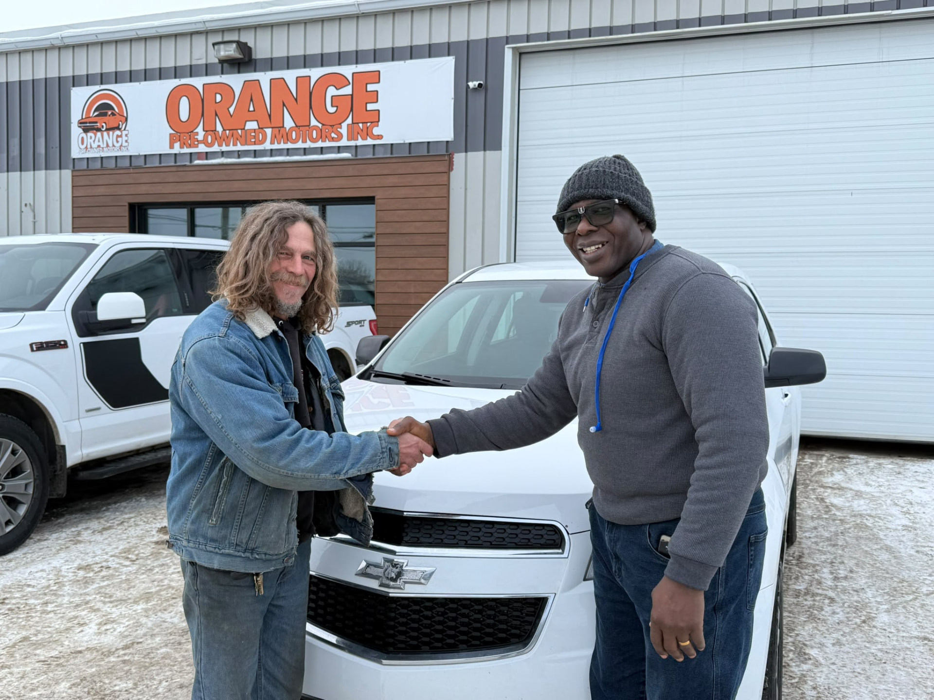 Happy Orange Auto customer with their vehicle