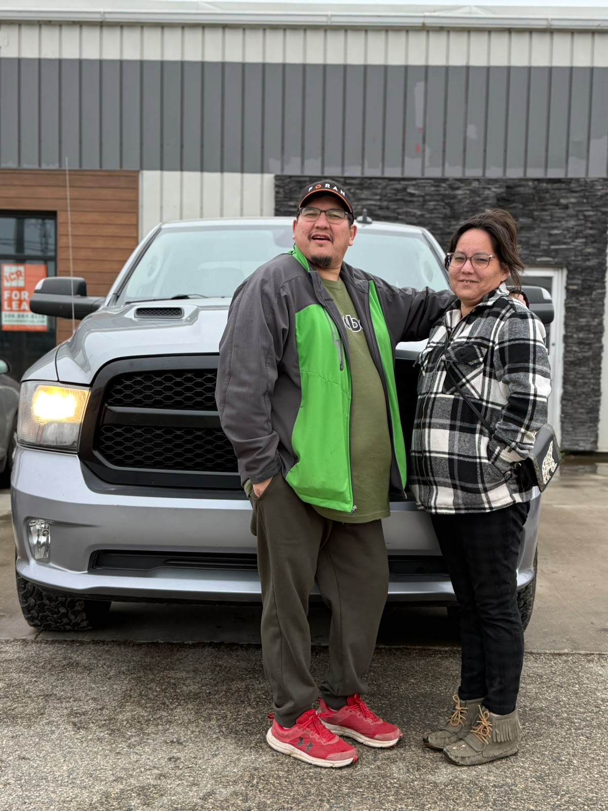 Happy Orange Auto customer with their vehicle