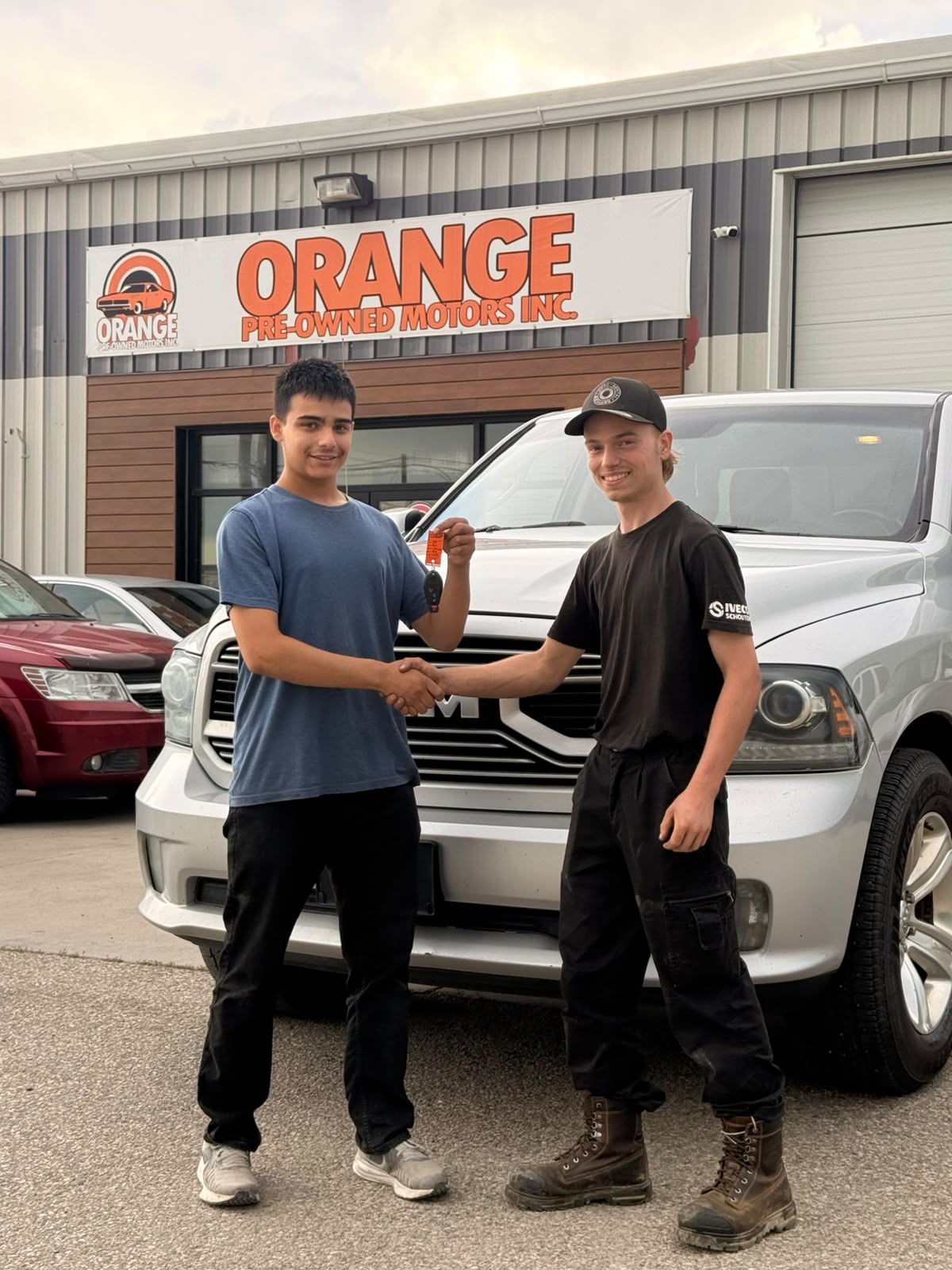 Happy Orange Auto customer with their vehicle