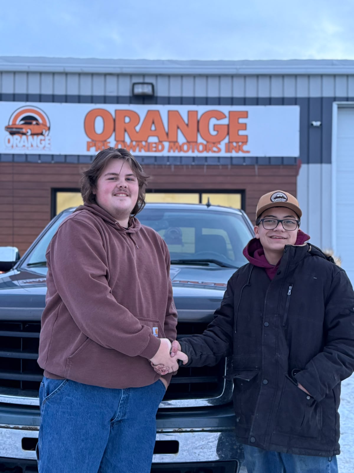 Happy Orange Auto customer with their vehicle