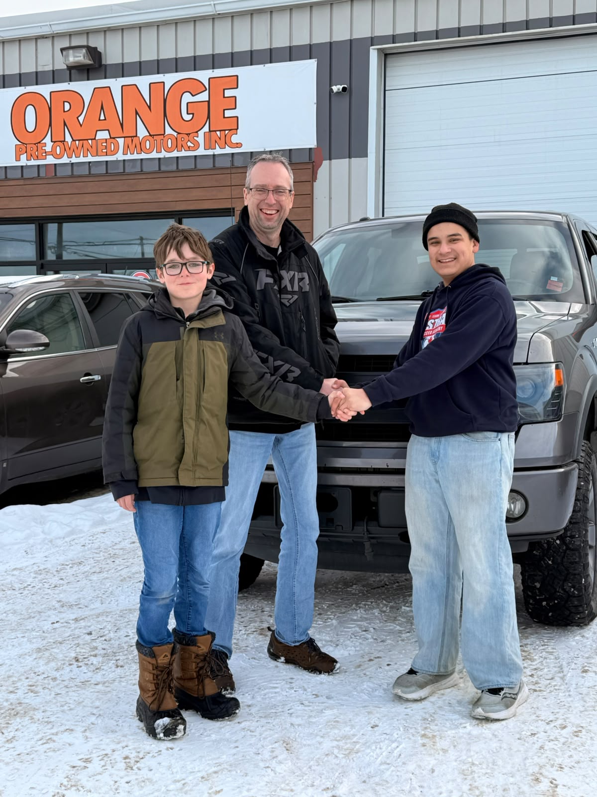 Happy Orange Auto customer with their vehicle