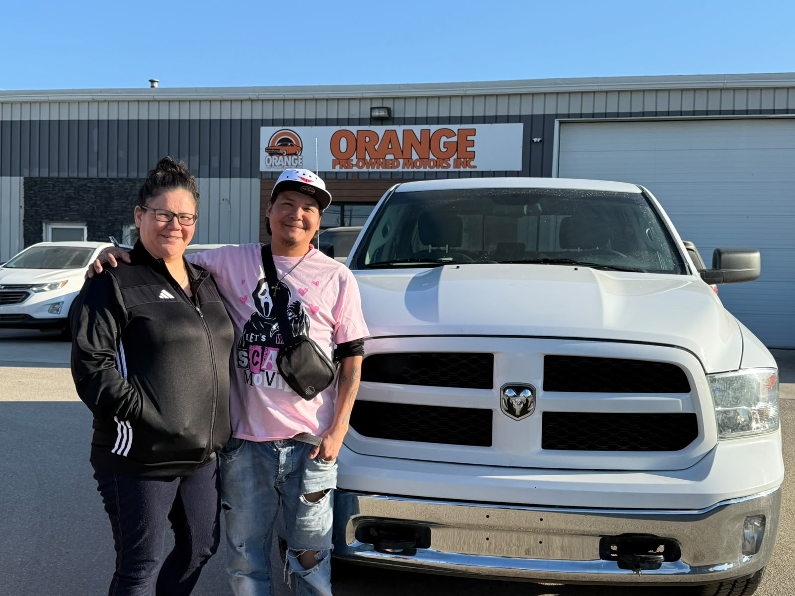 Happy Orange Auto customer with their vehicle