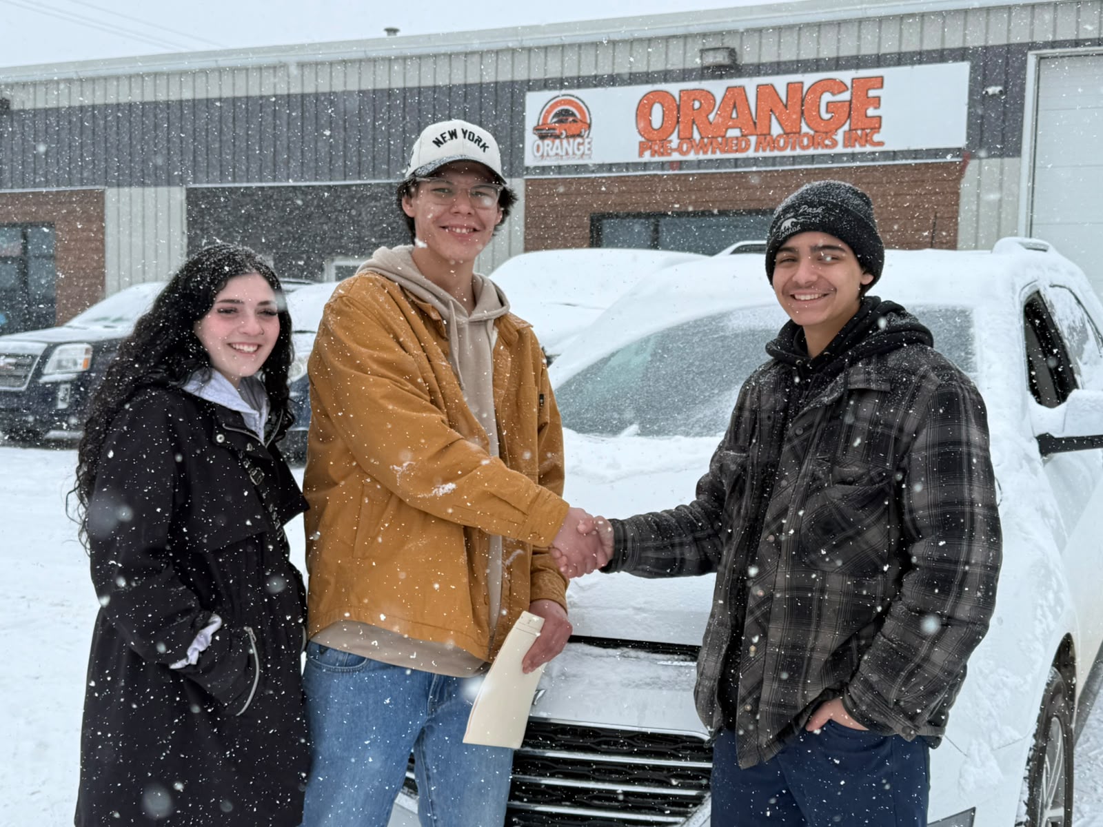Happy Orange Auto customer with their vehicle