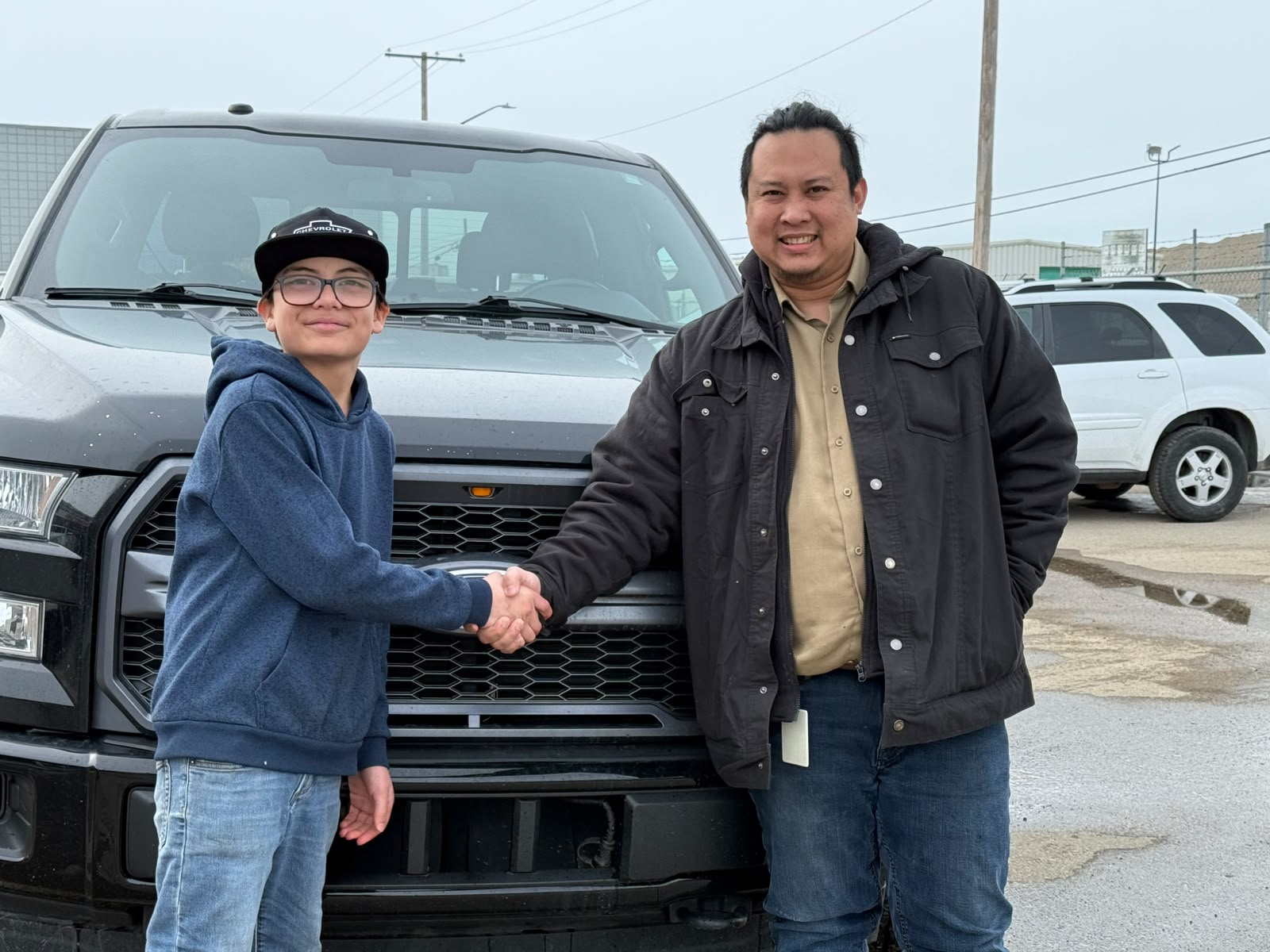 Happy Orange Auto customer with their vehicle