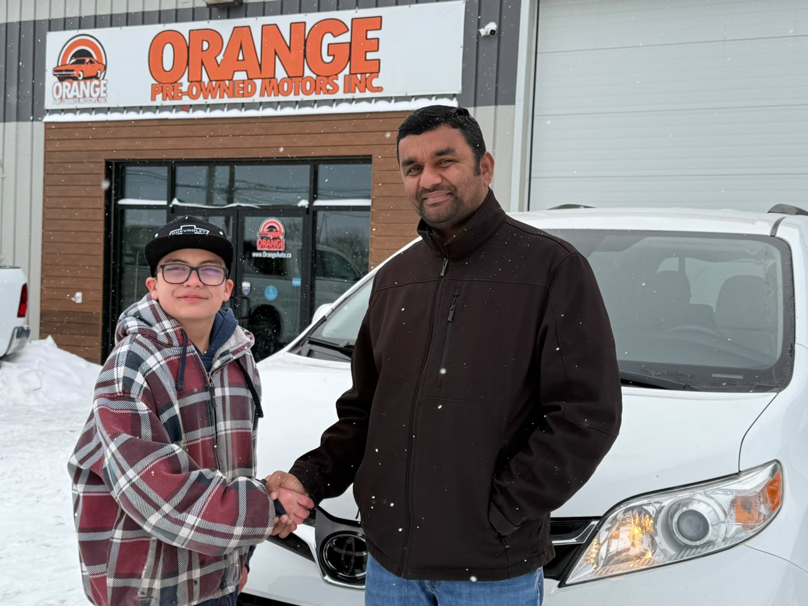 Happy Orange Auto customer with their vehicle