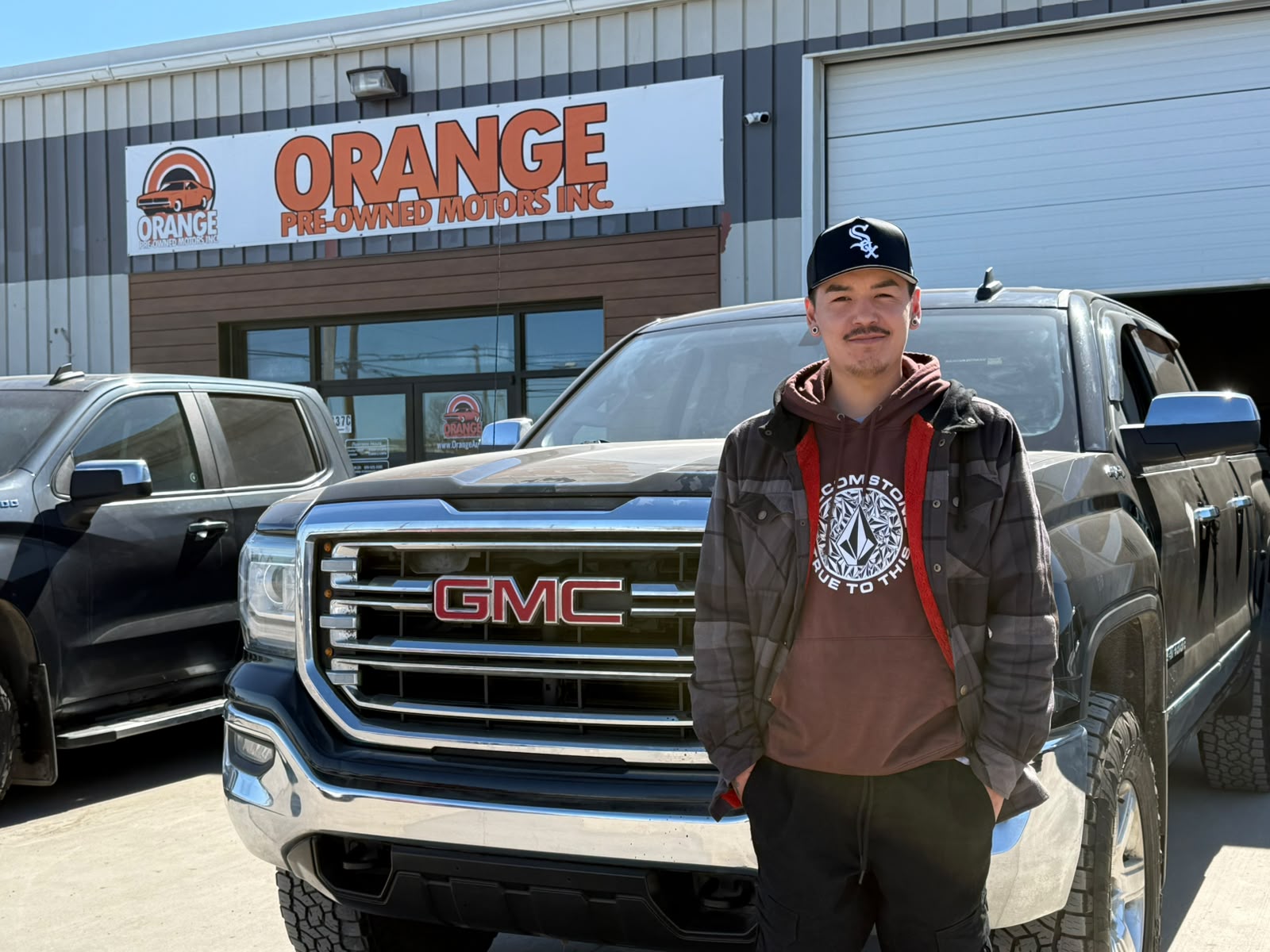 Happy Orange Auto customer with their vehicle