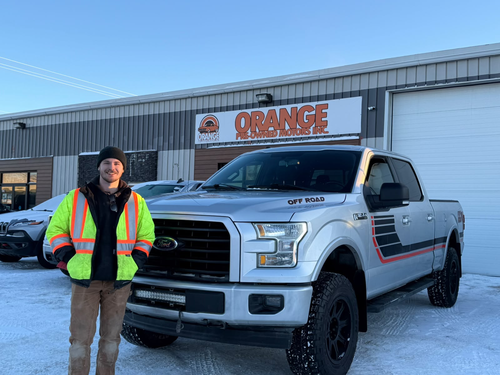 Happy Orange Auto customer with their vehicle