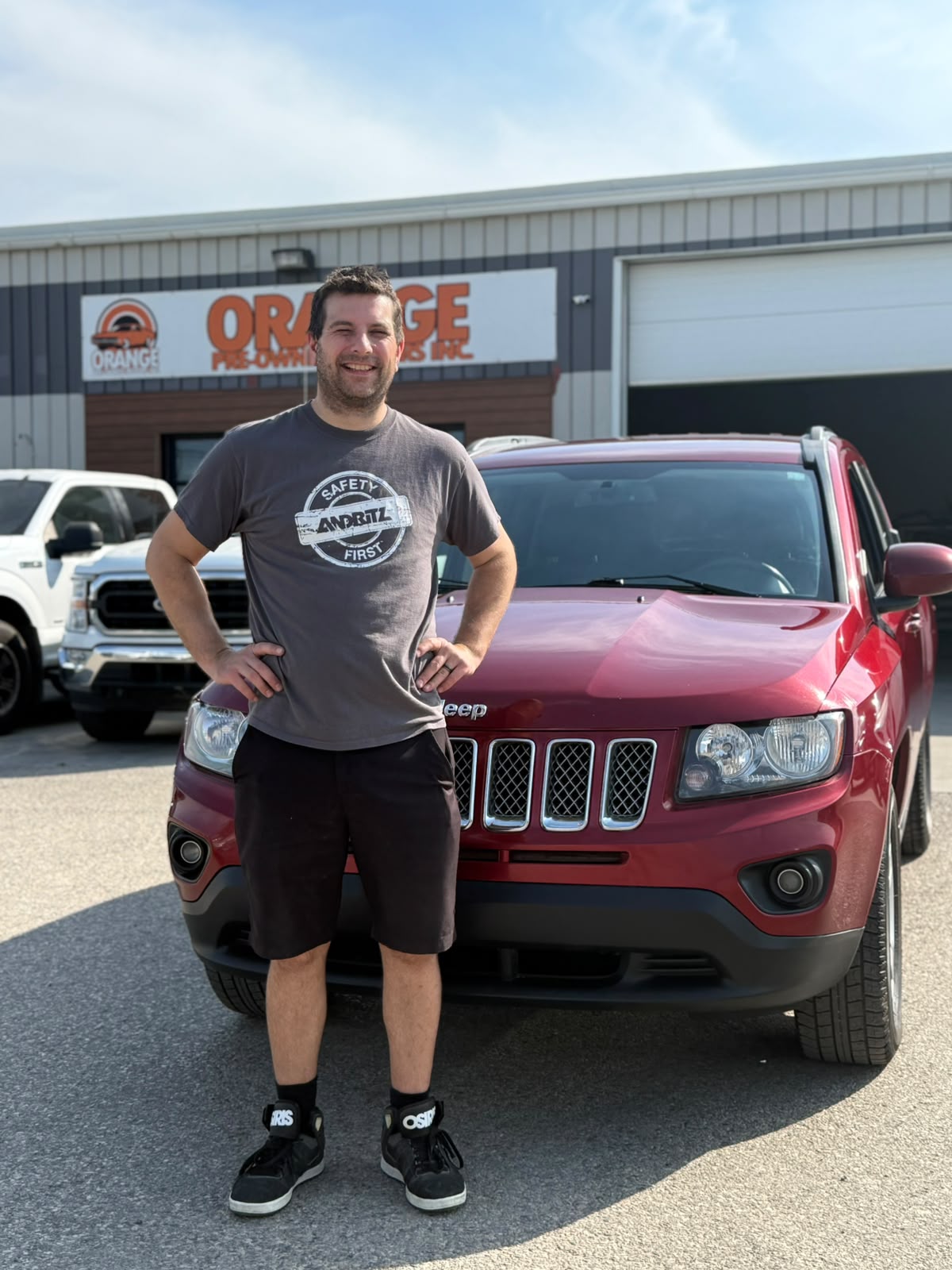 Happy Orange Auto customer with their vehicle