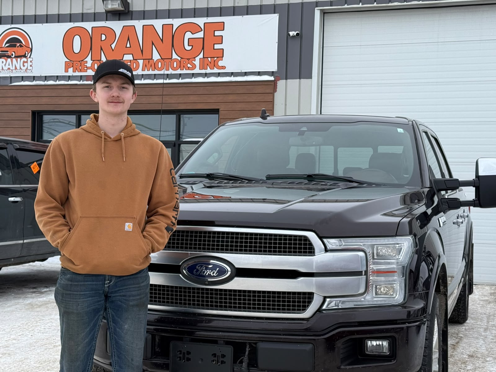 Happy Orange Auto customer with their vehicle