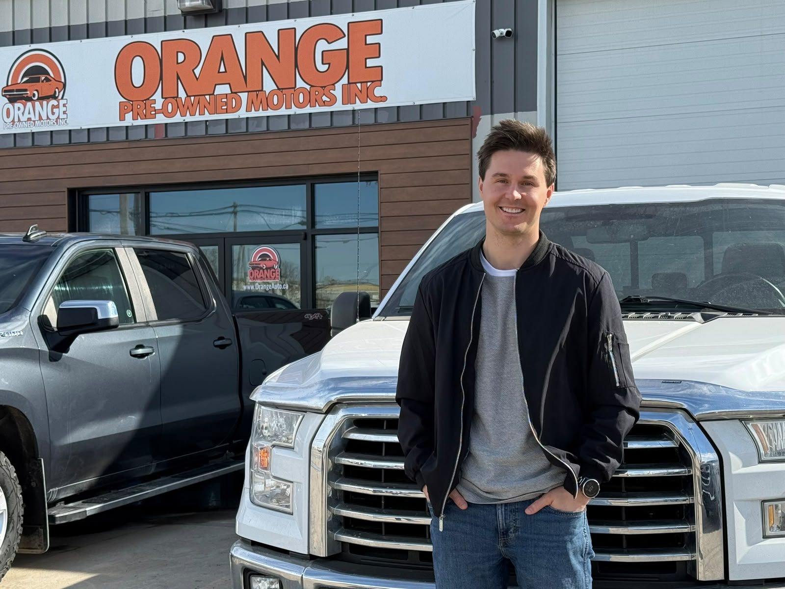 Happy Orange Auto customer with their vehicle