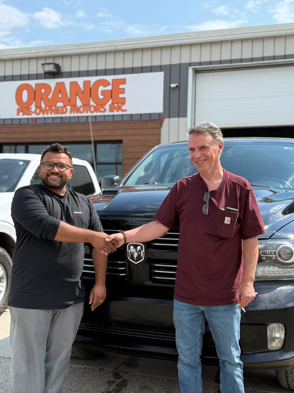 Happy Orange Auto customer with their vehicle