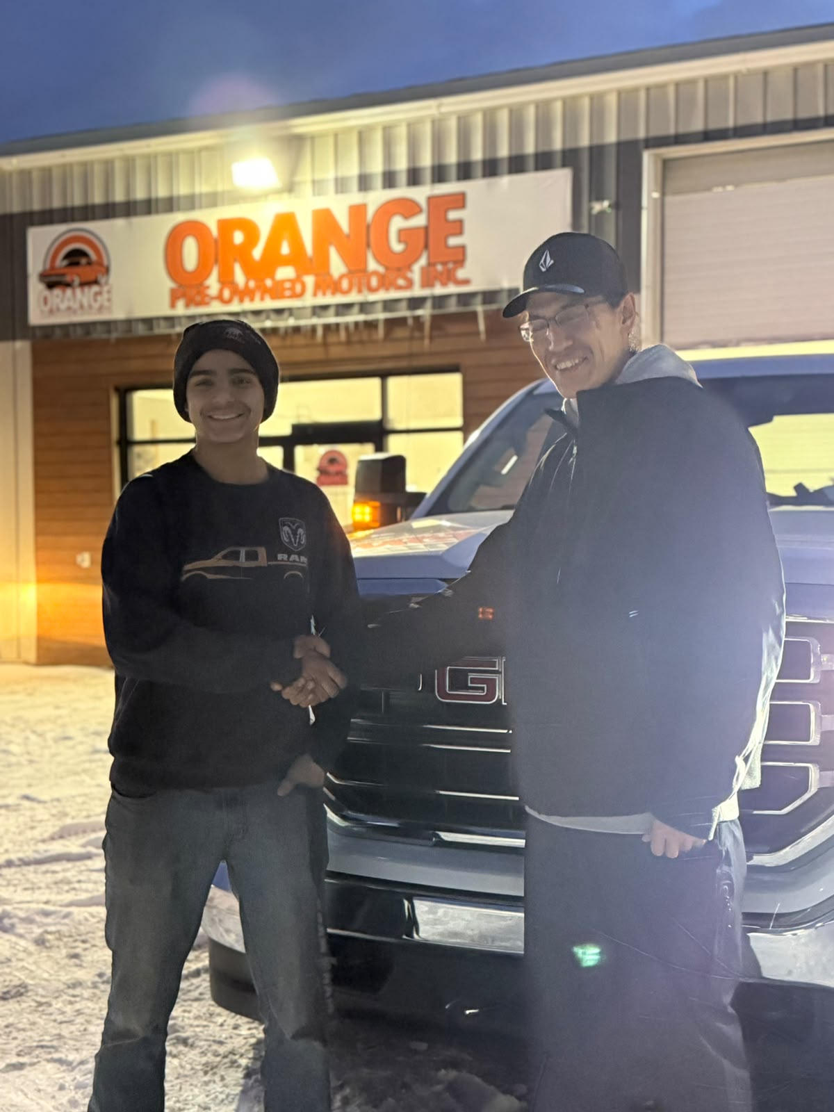 Happy Orange Auto customer with their vehicle
