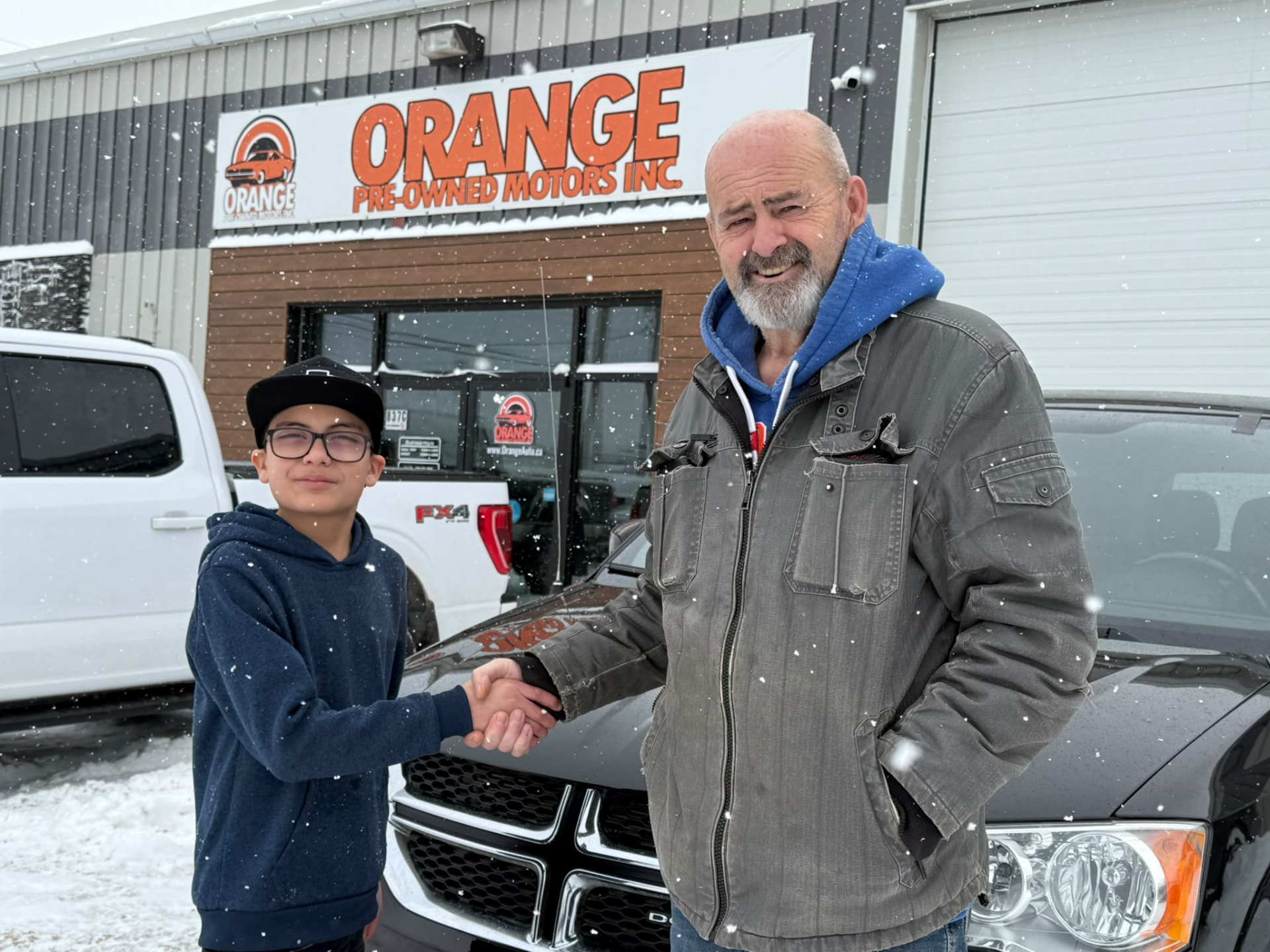 Happy Orange Auto customer with their vehicle