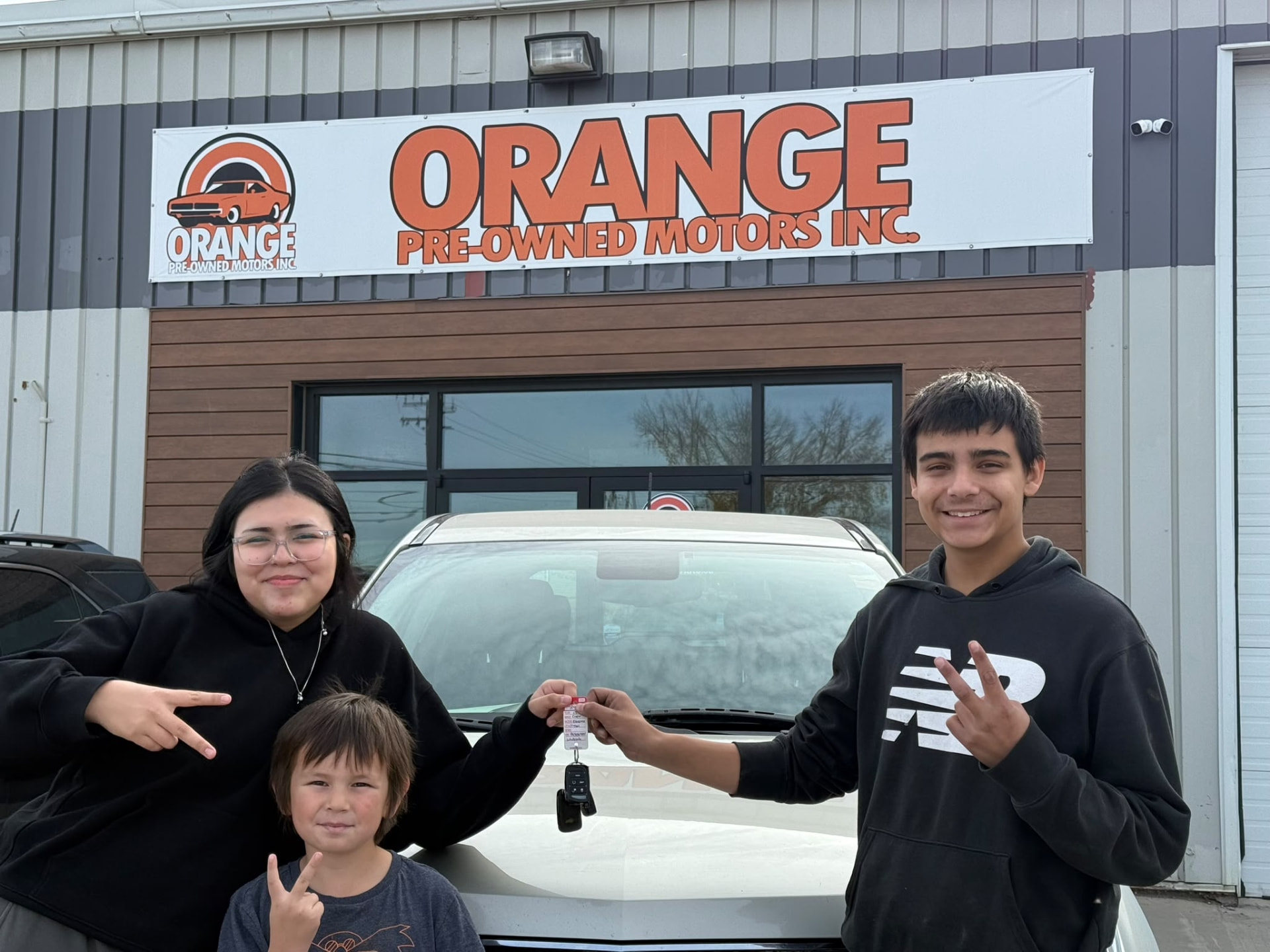 Happy Orange Auto customer with their vehicle