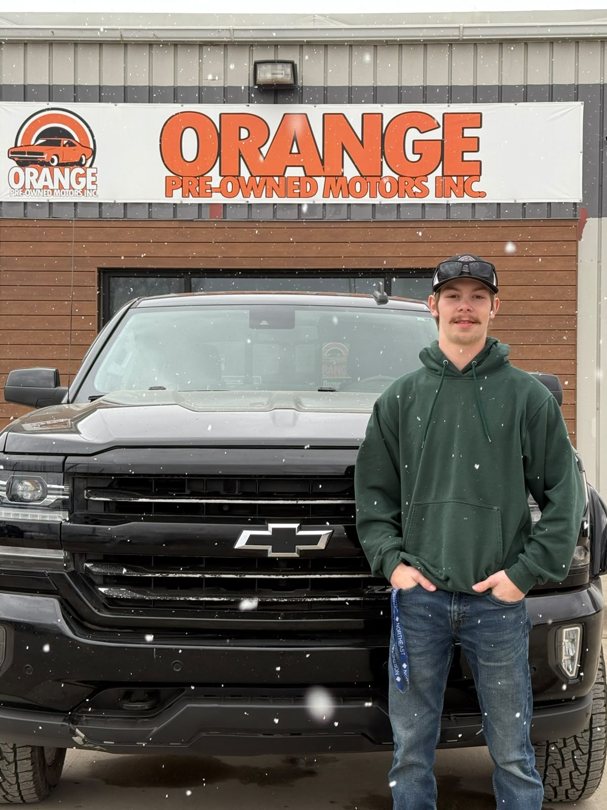 Happy Orange Auto customer with their vehicle