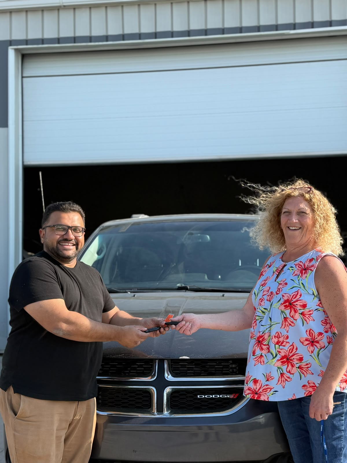 Happy Orange Auto customer with their vehicle