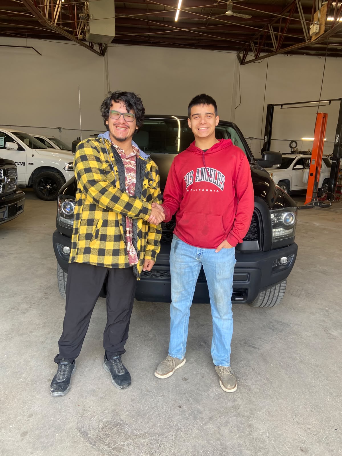 Happy Orange Auto customer with their vehicle